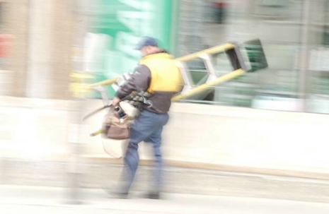 a worker carrying a ladder