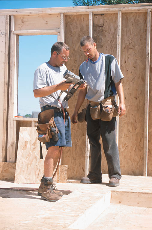 man wearing a tool belt working on wood